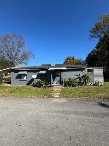 Single-story residence featuring a gray exterior, a dark shingle roof, and multiple window awnings