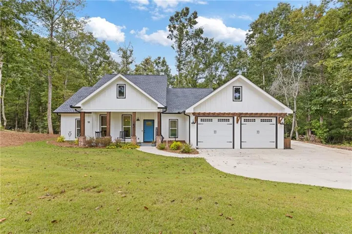 Modern farmhouse with an inviting covered porch and large, private front yard