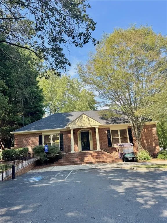 View of front of property featuring covered porch, brick siding, and a shingled roof