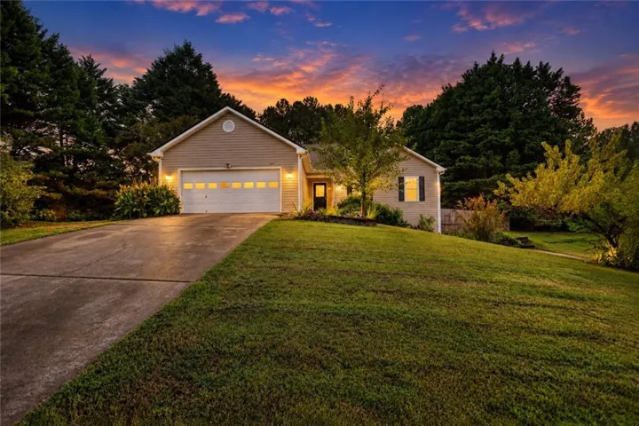 Ranch-style exterior with neutral siding, attached two-car garage, and a concrete driveway