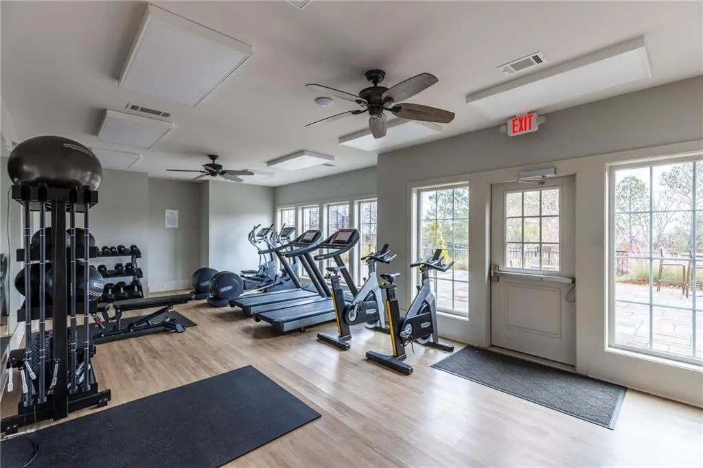 Workout area featuring wood finished floors, a ceiling fan, and attic access