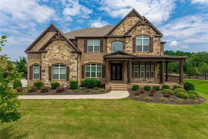 View of front of house featuring stone siding and covered porch