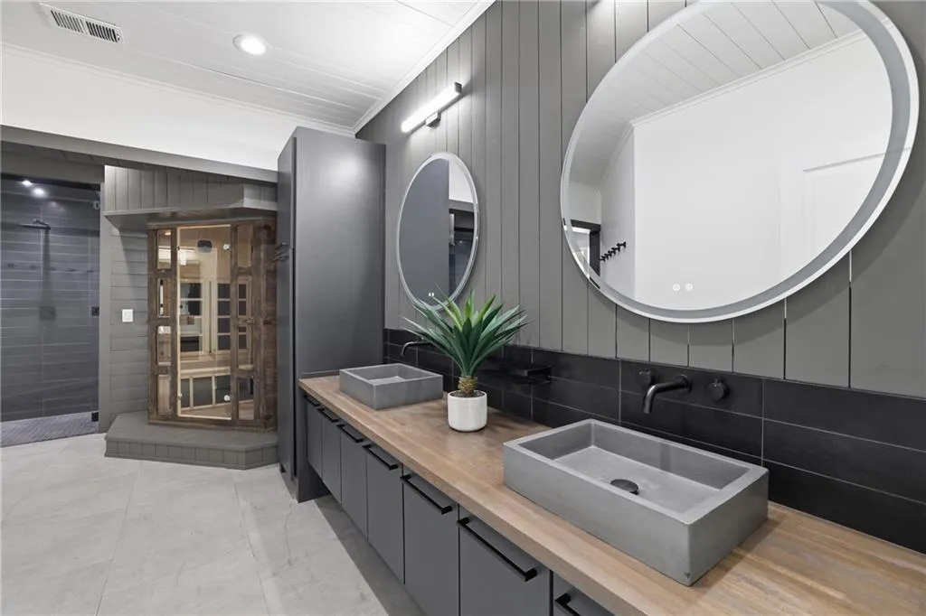 Contemporary vanity with dual concrete vessel sinks, wood-finish countertop, and matte black fixtures