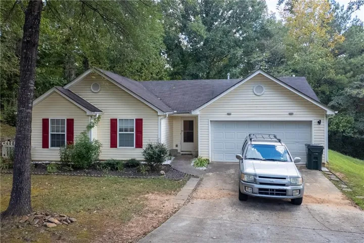Cream siding exterior with red window shutters