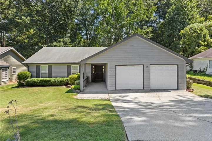 Exterior siding with horizontal panels, two-car garage, covered entry, and front landscaping