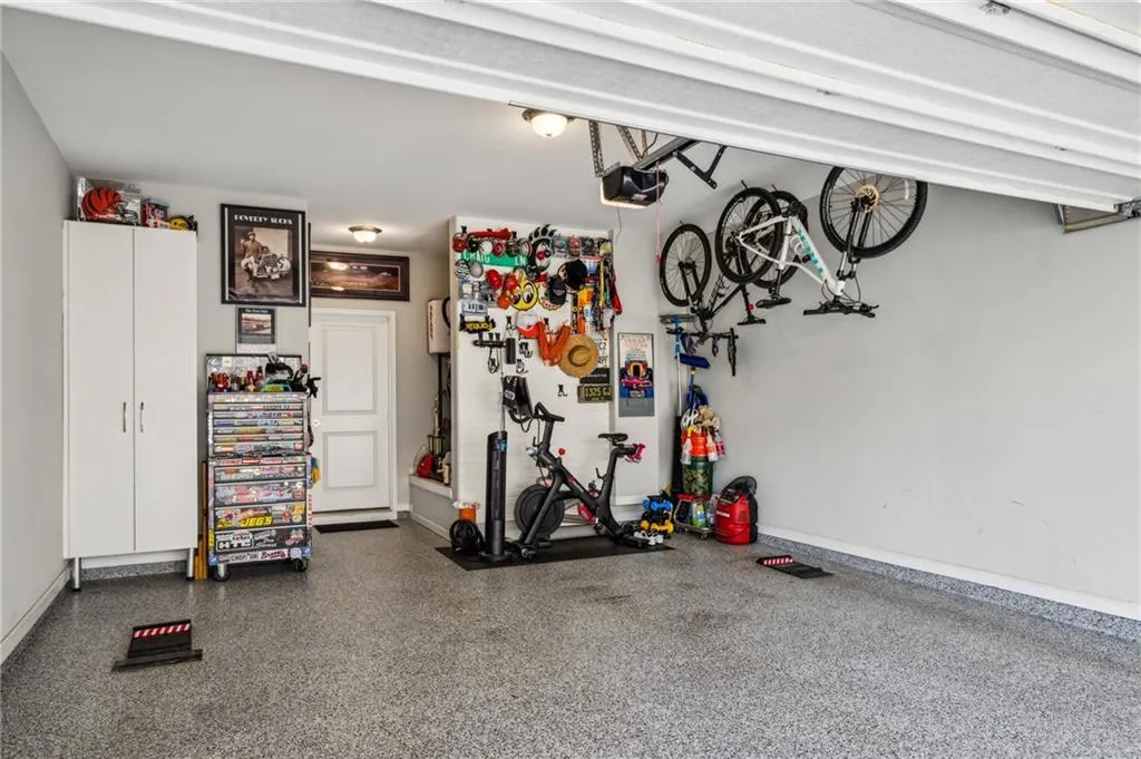 Garage with baseboards, epoxy floor and a garage door opener