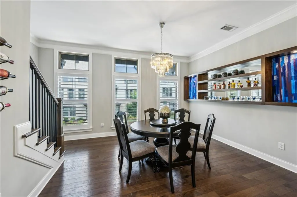 Dining space featuring crown molding, a chandelier, and dark wood floors