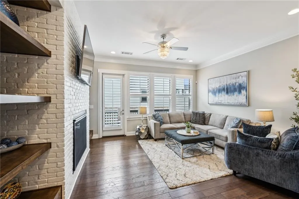 Living area featuring ornamental molding, dark wood flooring, ceiling fan, a fireplace, and recessed lighting