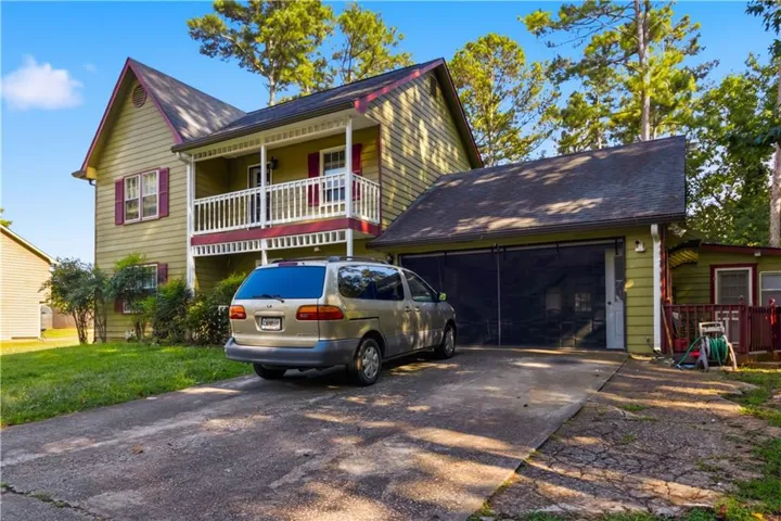 Two-story exterior with a second-level balcony, two-car garage, and a concrete driveway