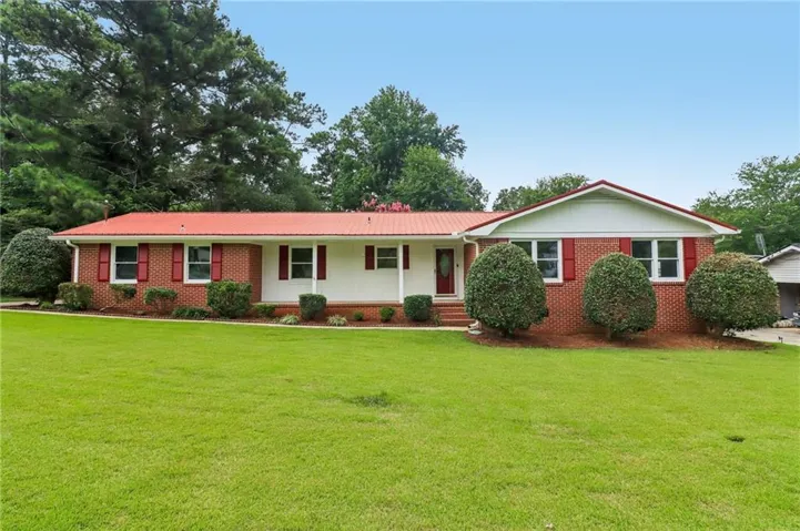 Brick facade residence with a red metal roof