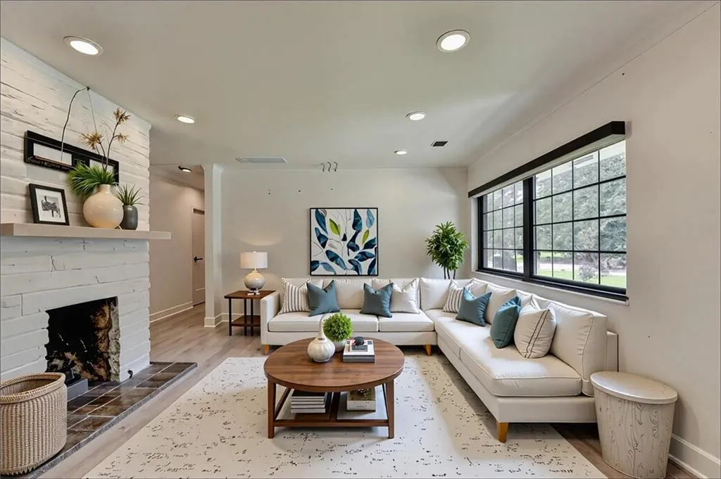 Living area with wood finished floors, recessed lighting, and a large fireplace