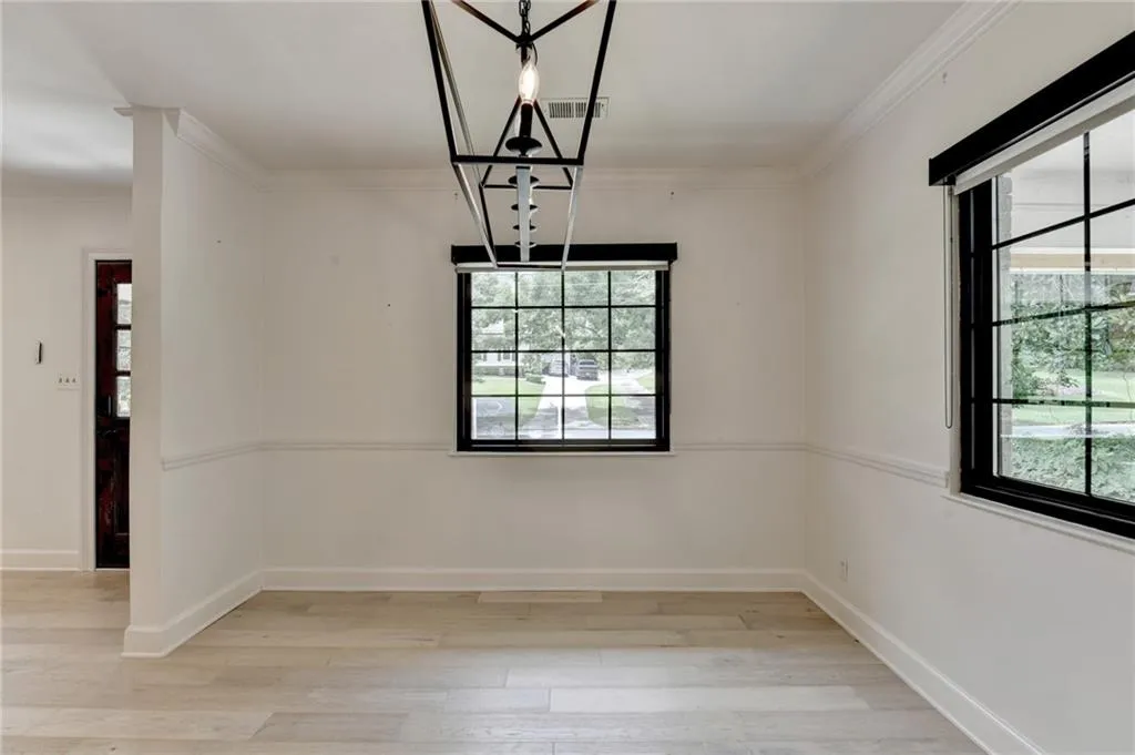 Unfurnished dining area featuring light wood-style floors and ornamental molding