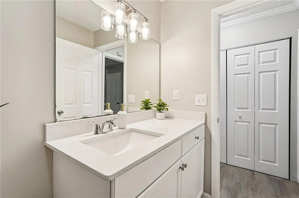 Bathroom featuring vanity, a chandelier, and light wood-style flooring