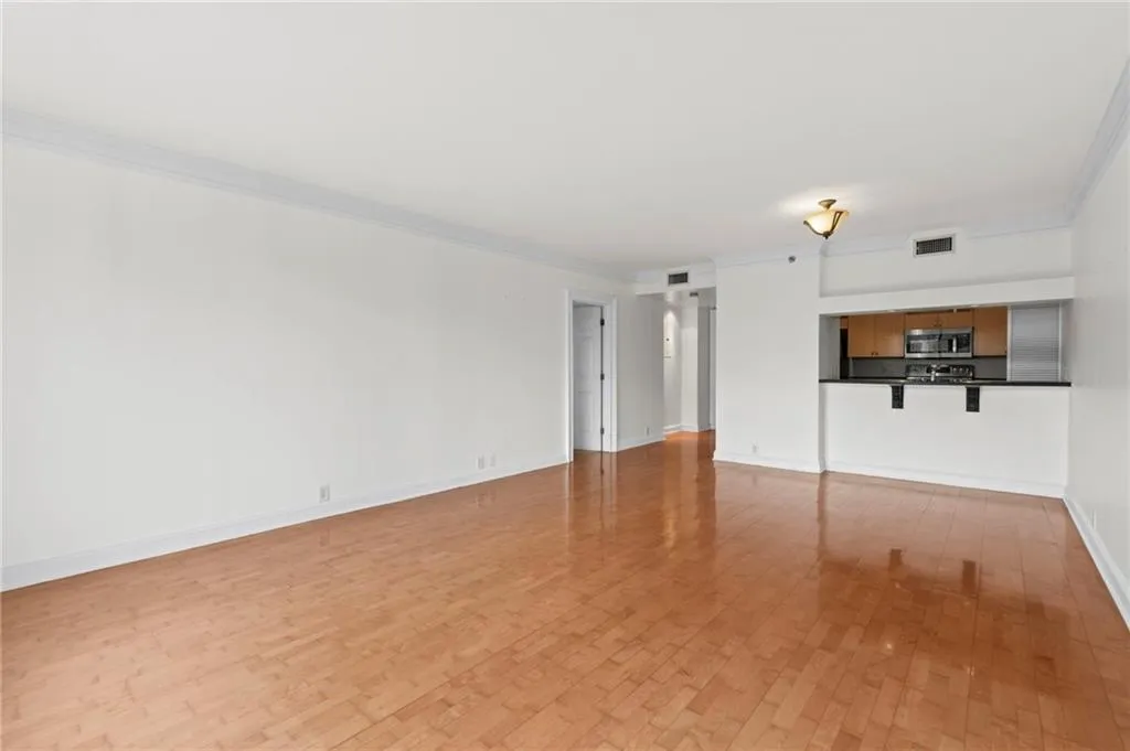 Unfurnished living room with crown molding and light wood-style flooring