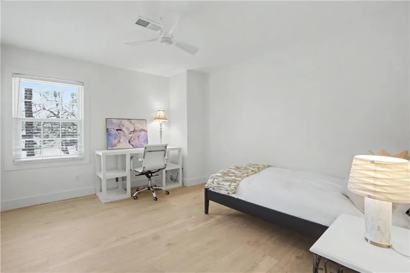 Bedroom featuring light wood-type flooring, a desk, and ceiling fan