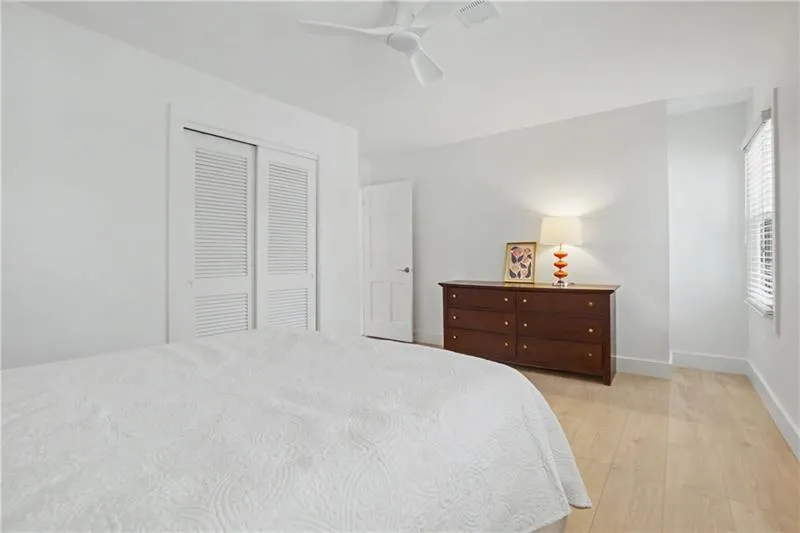 Bedroom featuring light wood-style floors, a closet, and a ceiling fan