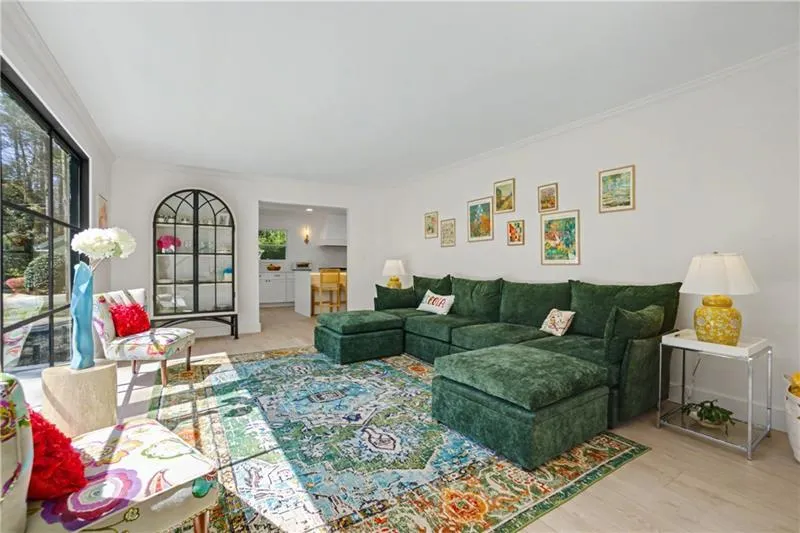 Living room with light wood-type flooring and crown molding