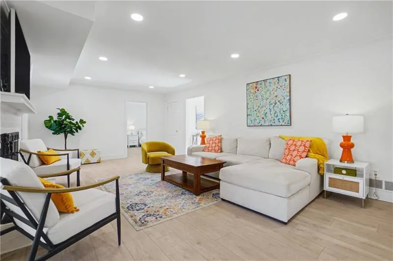 Living room featuring light wood finished floors, recessed lighting, and a fireplace