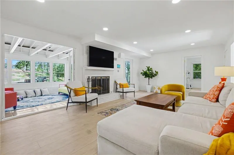 Living area with light wood-style floors, a fireplace, and recessed lighting