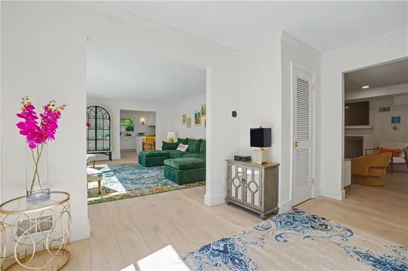 Living room featuring light wood finished floors, ornamental molding, and a fireplace