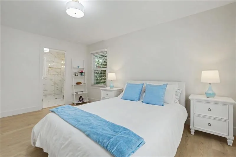 Bedroom with light wood-style floors and ensuite bathroom