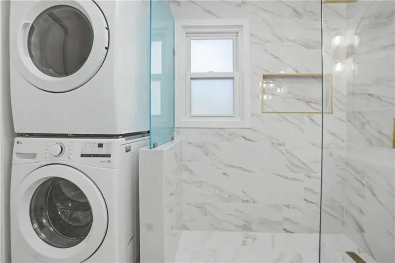 Laundry area featuring stacked washing machine and dryer