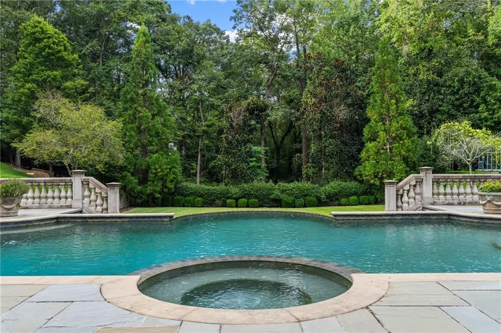 Swimming pool with integrated spa and stone coping