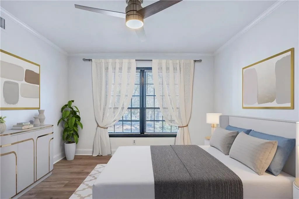 Bedroom featuring wood finished floors, crown molding, and ceiling fan