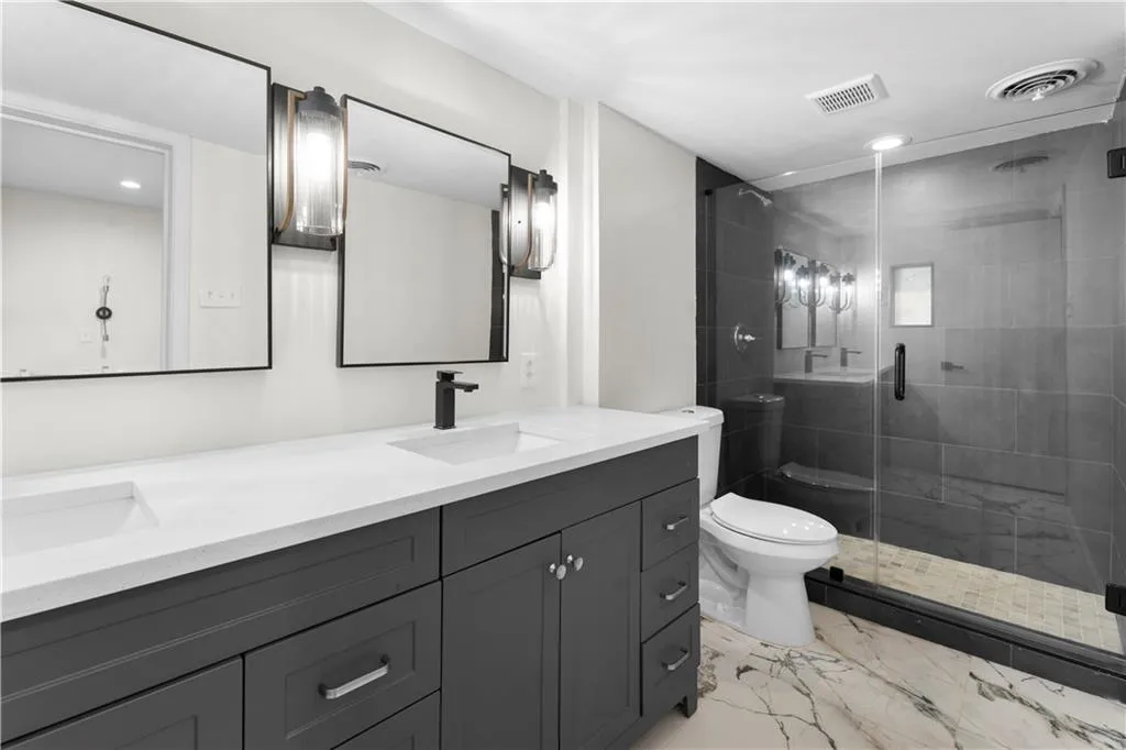 Full bath with recessed lighting, double vanity, a stall shower, and light marble finish floors
