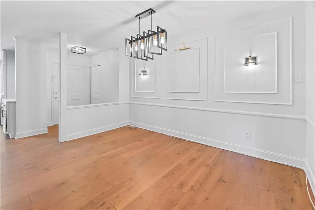 Unfurnished dining area featuring light wood-style floors and ornamental molding