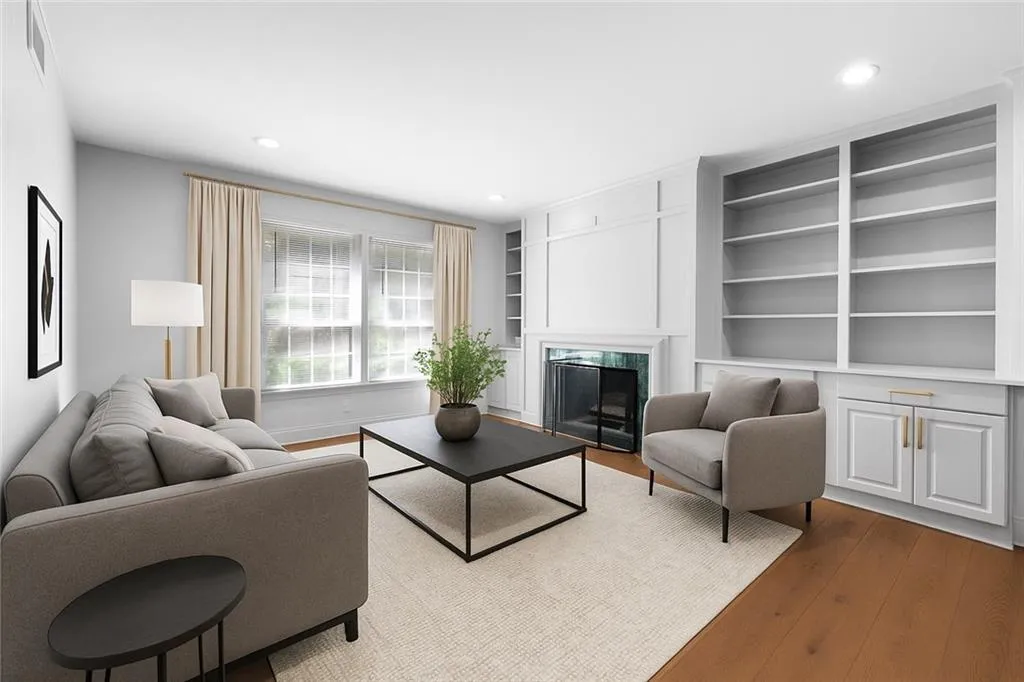 Living area with wood finished floors, built in shelves, a fireplace, and recessed lighting