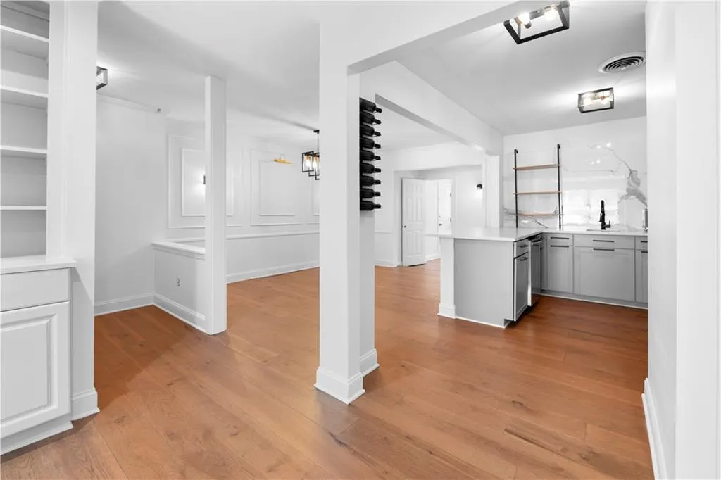 Kitchen with a peninsula, light wood-style flooring, gray cabinetry, light stone countertops, and open floor plan
