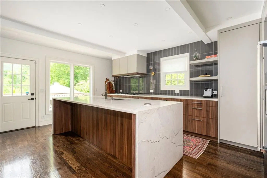 Large center island with waterfall-edge quartzite countertop