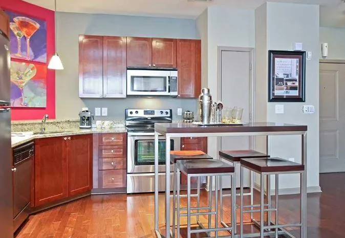 Kitchen featuring light hardwood / wood-style flooring, black dishwasher, hanging light fixtures, sink, and electric range oven