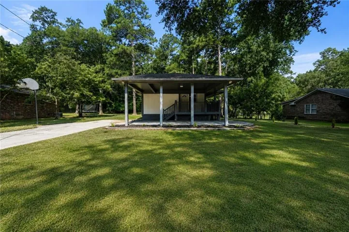 Covered front porch with dark gray railing and steps, white siding, and a dark roof