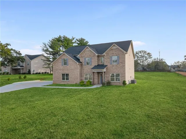 Traditional-style home with a front yard and brick siding