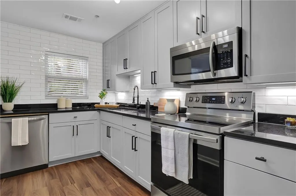 Kitchen featuring tasteful backsplash, dark wood-type flooring, and stainless steel appliances