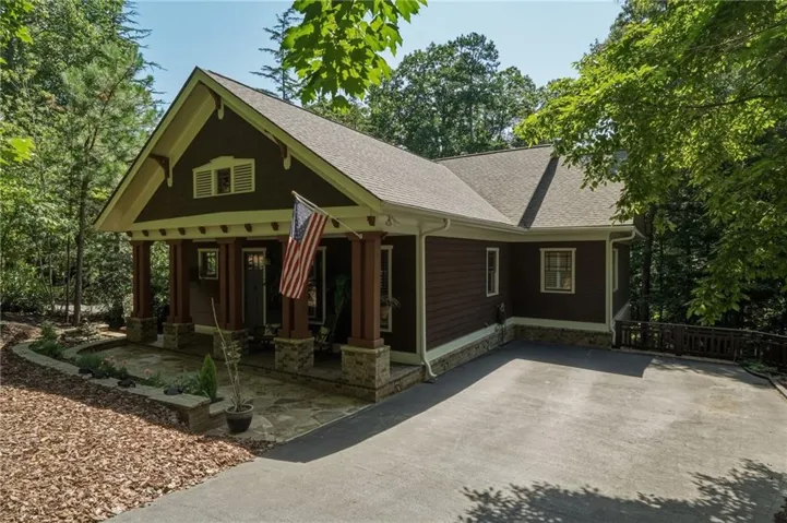 Craftsman-style home featuring a covered front porch with stone-wrapped columns