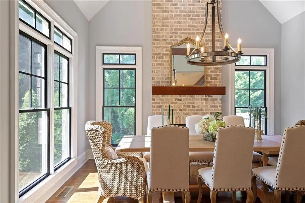 Breakfast area with a wealth of natural light, hardwood flooring and fireplace