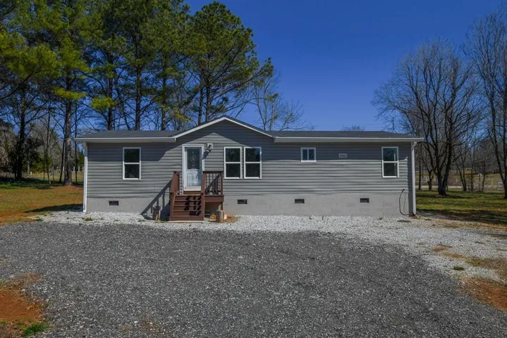 Single-story residence featuring gray horizontal siding and a dark gray shingle roof