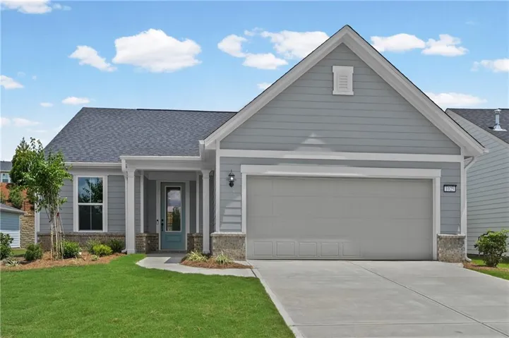 Light blue siding exterior featuring a covered entry, decorative stone accents, and an attached two-car garage