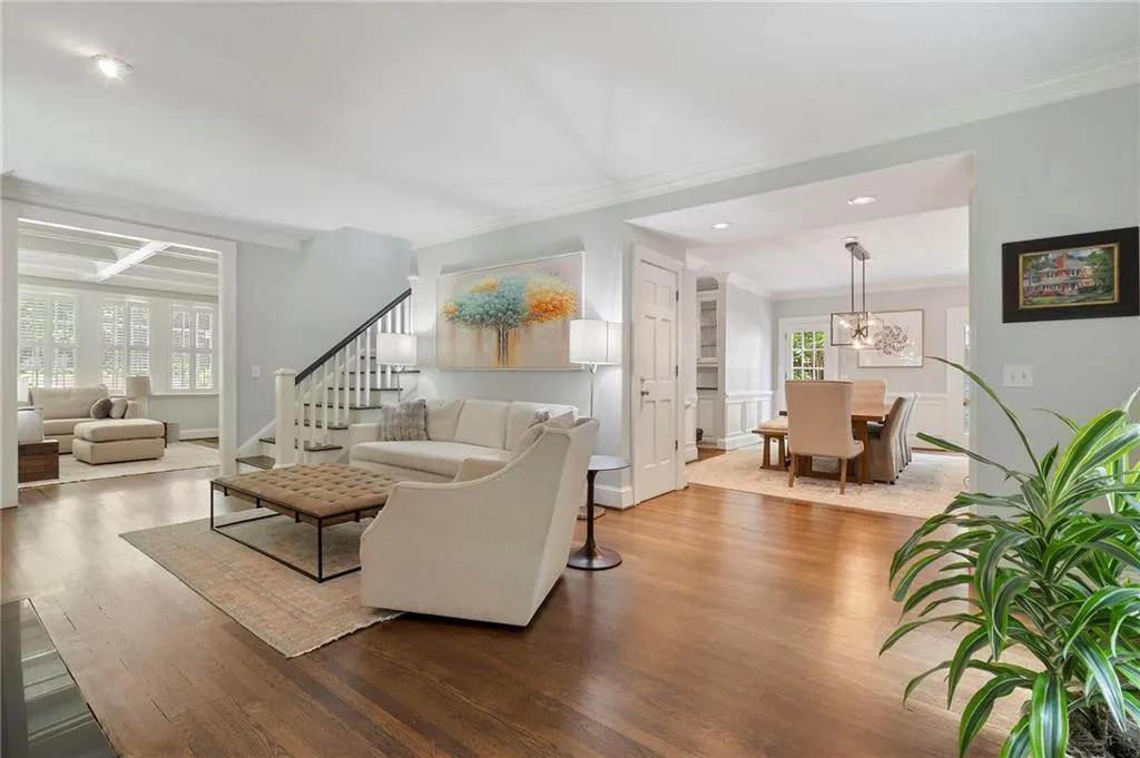 Living area featuring crown molding, wood finished floors, a chandelier, stairs, and recessed lighting