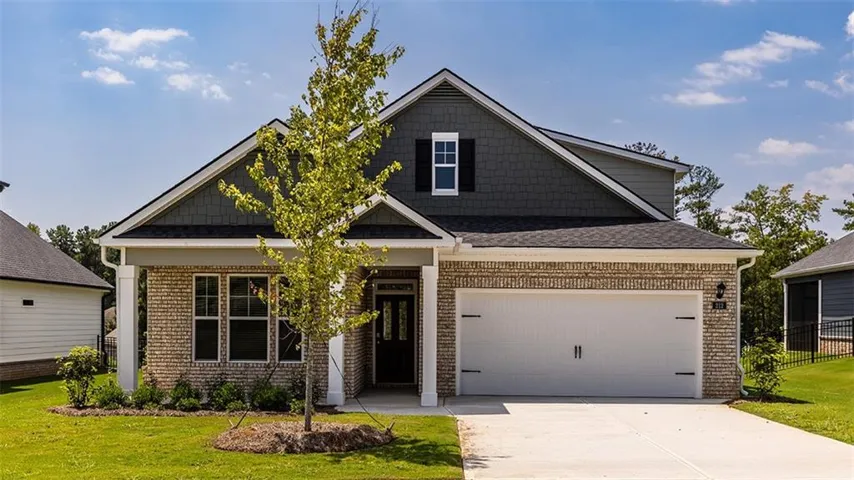 Brick and siding exterior with shingle accents and a covered entry