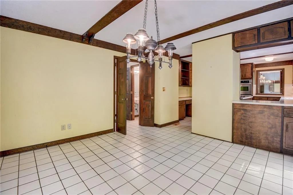 dining area with a chandelier and light tile floors