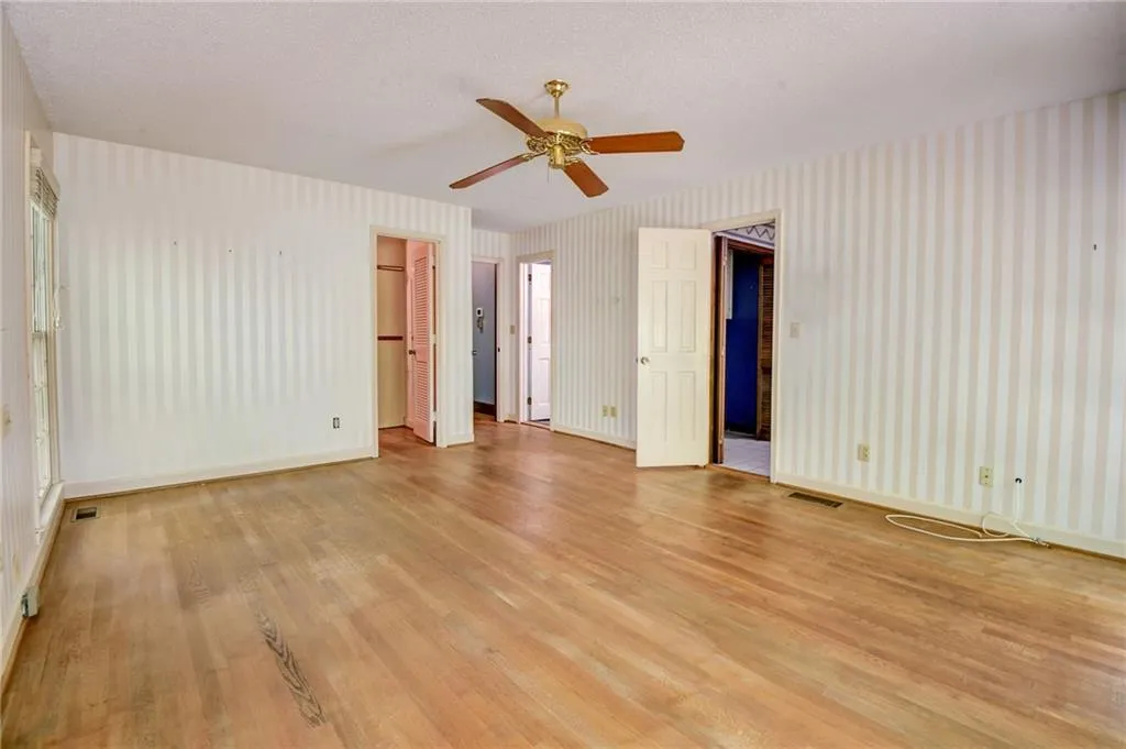 Bedroom on main  with a textured ceiling, ceiling fan, and light hardwood / wood-style floors