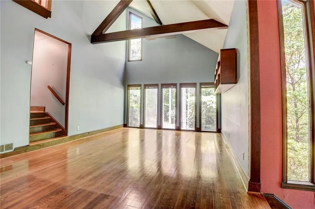 living room featuring beamed ceiling, hardwood / wood-stylefloors, and high vaulted ceiling