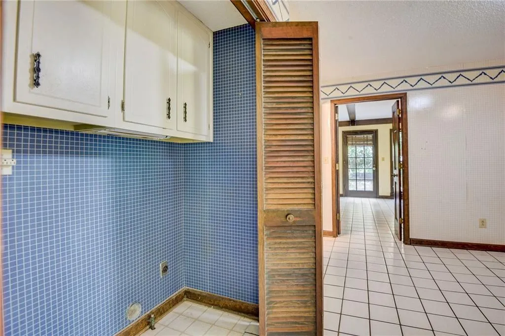 Washroom with tile walls and light tile floors