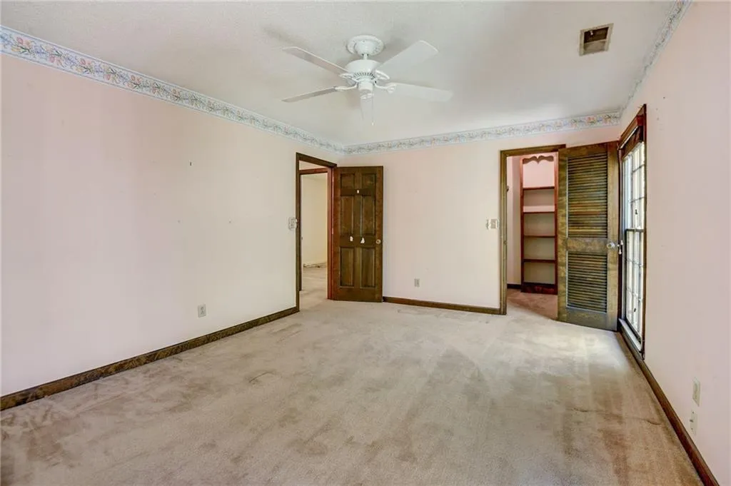 Bed room with ceiling fan and walk in closet