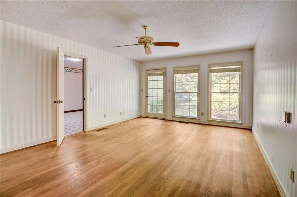 Bedroom featuring light hardwood / wood-style floors, ceiling fan, and a textured ceiling