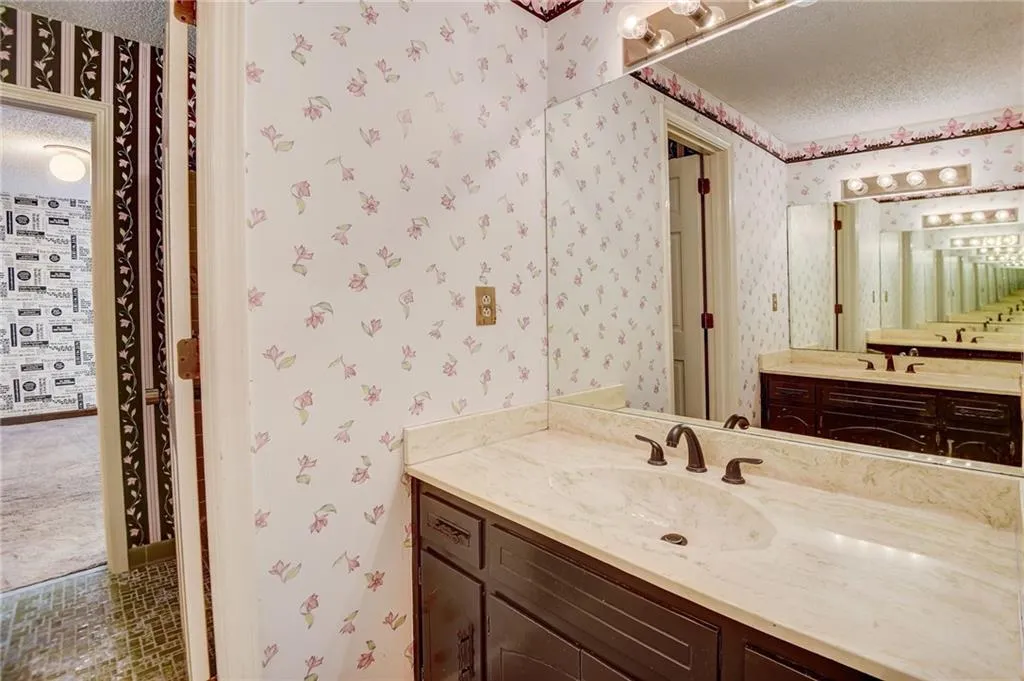 Bathroom featuring a textured ceiling, vanity, and tile floors